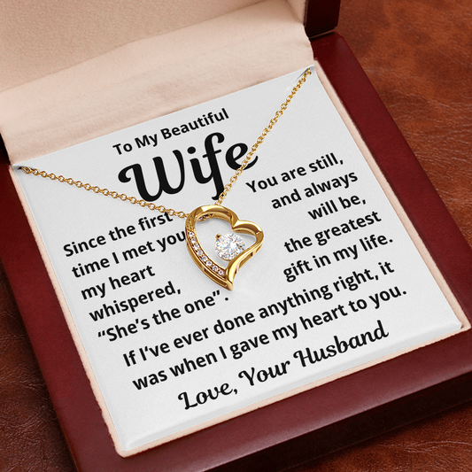 Meaningful gift to wife from husband heart-shaped necklace with sentimental message card on a wooden box.