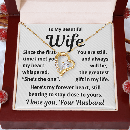 Necklace with heart design on a card for a wife, placed in a wooden box.